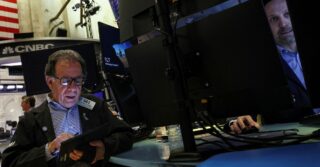 Wall St начинает год с падения; акции Apple и Tesla снижаются