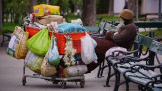 Бездомный мужчина живет на скамейке возле акимата Караганды