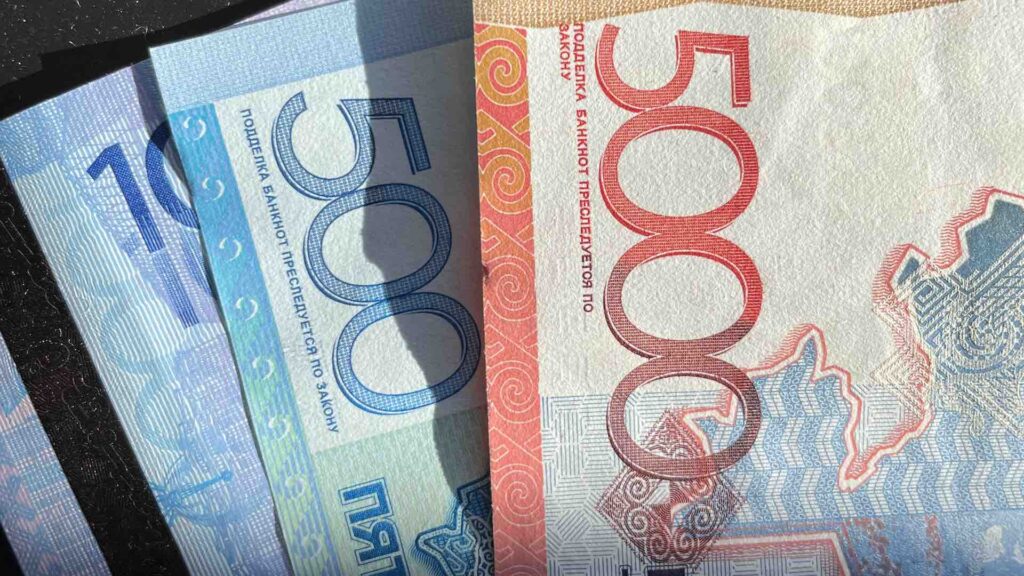 Купюры в 10000, 500 и 5000 тенге лежат на столе
