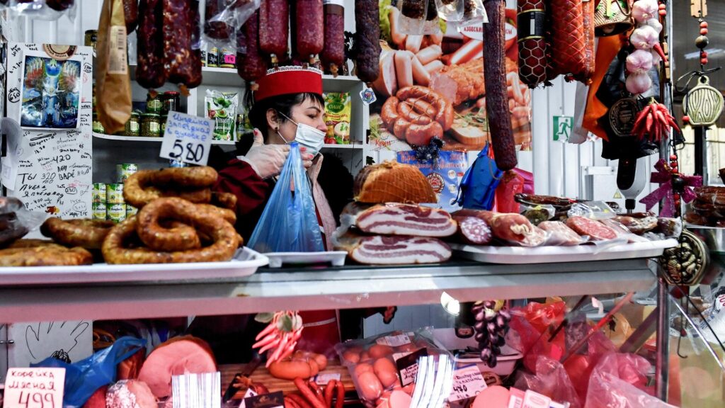 Женщина за прилавком с мясом