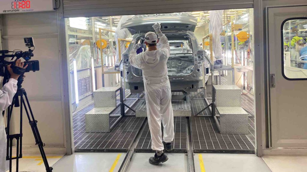 Работник проверяет собранный каркас автомобиля