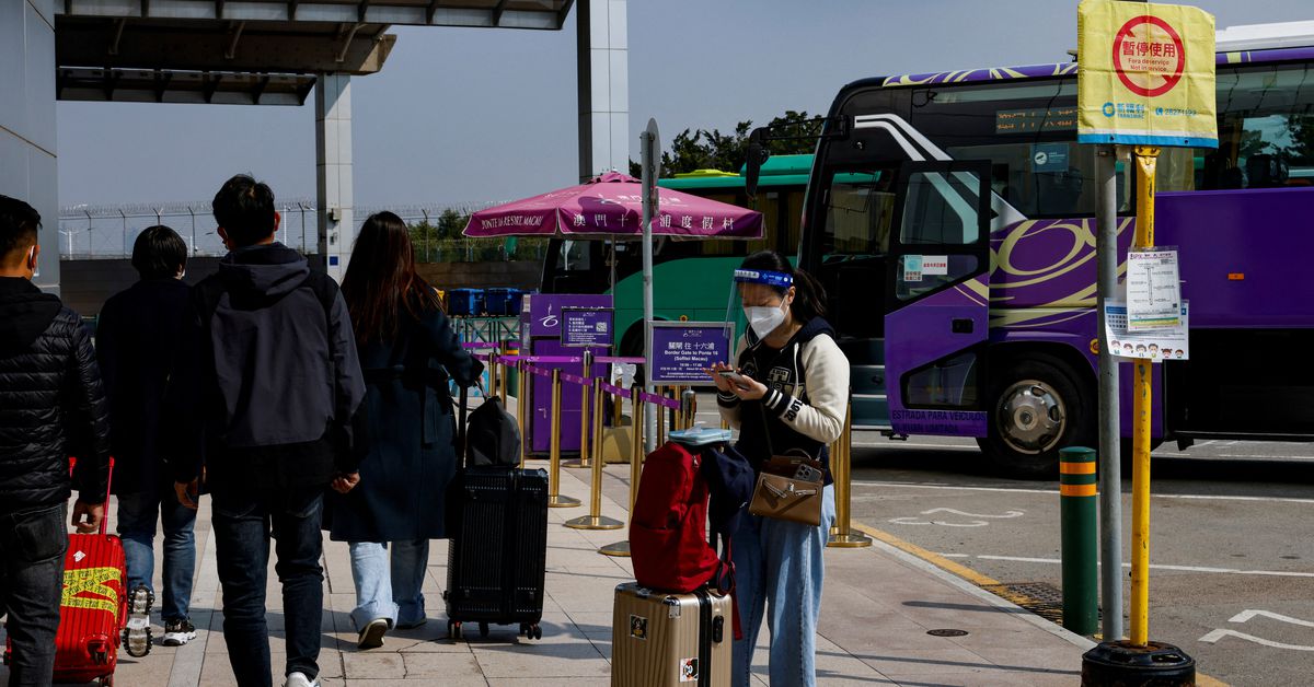Chinese travellers wear face masks outside the border checkpoint with the neighbouring city of Zhuhai, in Macau