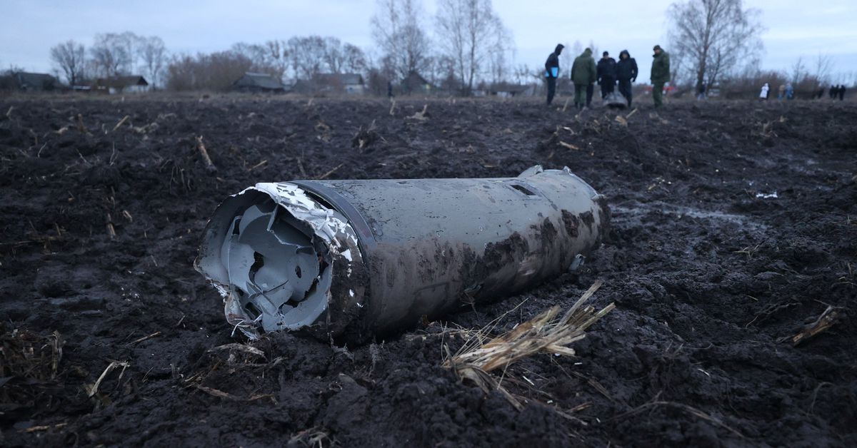 Investigators gather near a fragment of a munition in the Grodno region